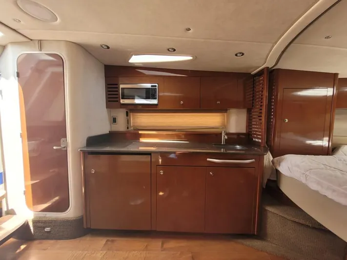 Knot On Call Yacht Photos Pics 2013 Sea Ray Sundancer 370 interior with kitchenette, microwave, and bed.
