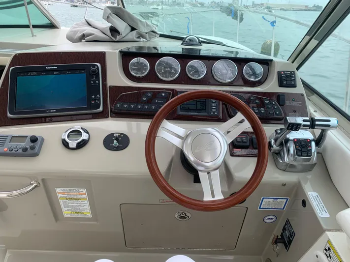 Knot On Call Yacht Photos Pics Helm of 2013 Sea Ray Sundancer 370 with wooden steering wheel and navigation instruments.