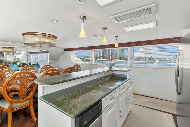 Envision Yacht Photos Pics Luxurious interior of 1984 Broward 110 Motor Yacht with elegant dining area and modern kitchen.