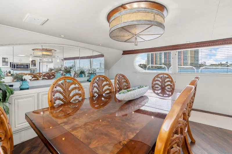 Envision Yacht Photos Pics Luxurious dining area on 1984 Broward 110 Motor Yacht with elegant wood table and chairs.