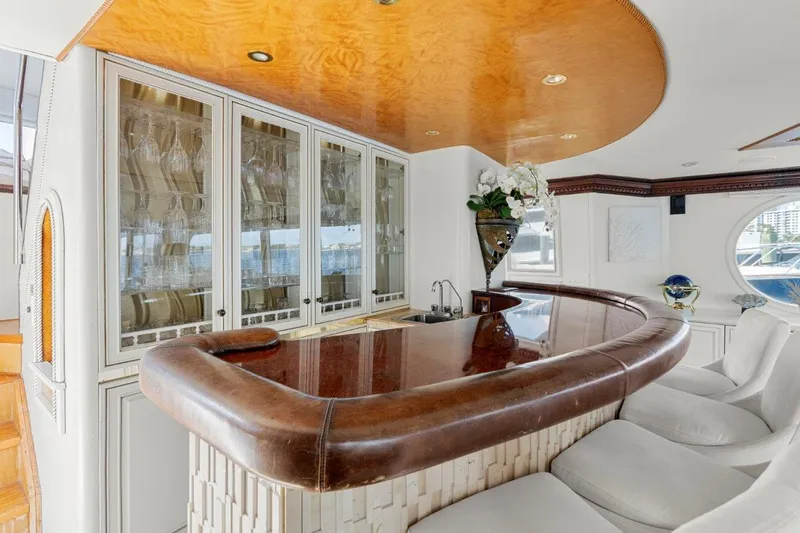 Envision Yacht Photos Pics Luxurious bar area inside 1984 Broward 110 Motor Yacht with elegant seating and cabinetry.