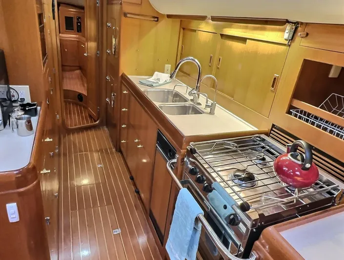 Celebrate Yacht Photos Pics Luxurious 2003 Taswell 58 yacht kitchen with wood finish, dual sinks, and stove.