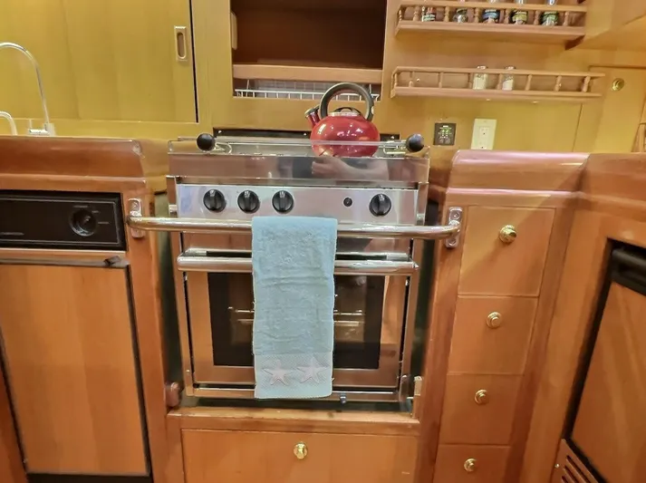 Celebrate Yacht Photos Pics Galley kitchen in 2003 Taswell 58 yacht with stove, red kettle, and towel.