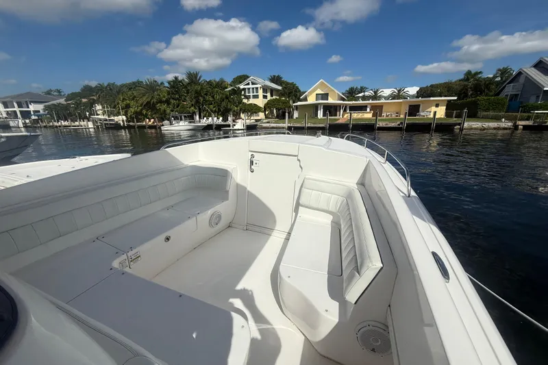  Yacht Photos Pics 2013 Intrepid 327 Cuddy boat interior with white seating, docked by waterfront homes.