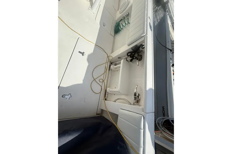  Yacht Photos Pics 2013 Intrepid 327 Cuddy boat deck with storage compartments and coiled hose.
