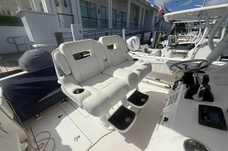  Yacht Photos Pics 2013 Intrepid 327 Cuddy boat interior with white seating and steering wheel.