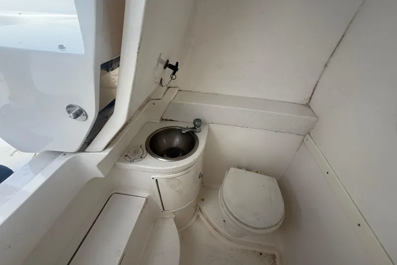  Yacht Photos Pics 2013 Intrepid 327 Cuddy boat interior with compact bathroom and sink.
