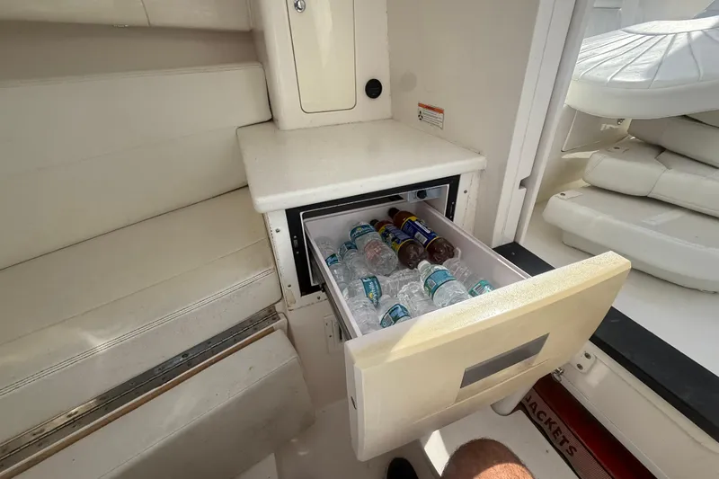  Yacht Photos Pics 2013 Intrepid 327 Cuddy boat interior with open cooler drawer containing drinks.