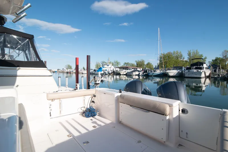  Yacht Photos Pics 2015 Pursuit OS 345 Offshore boat docked in a serene marina under a clear blue sky.