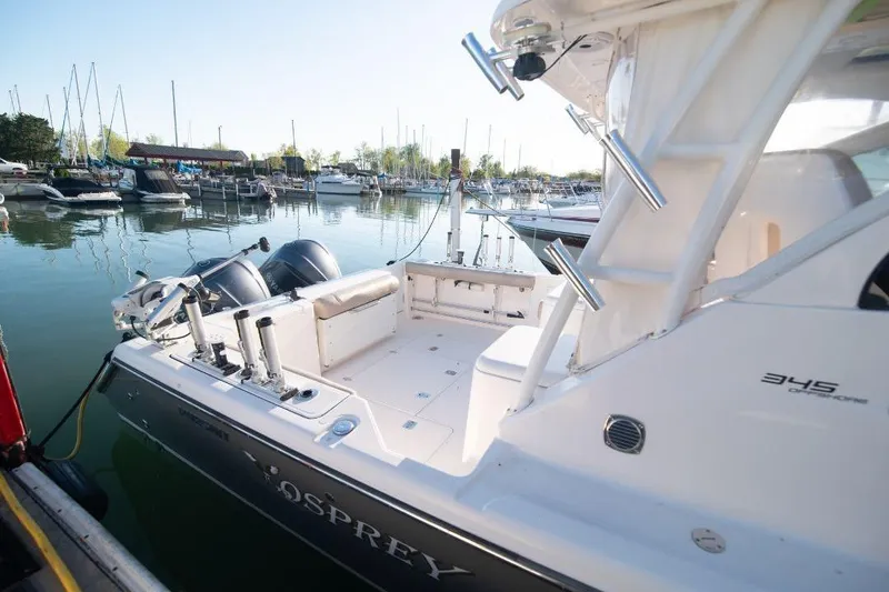  Yacht Photos Pics 2015 Pursuit OS 345 Offshore boat docked in a marina, featuring dual engines.