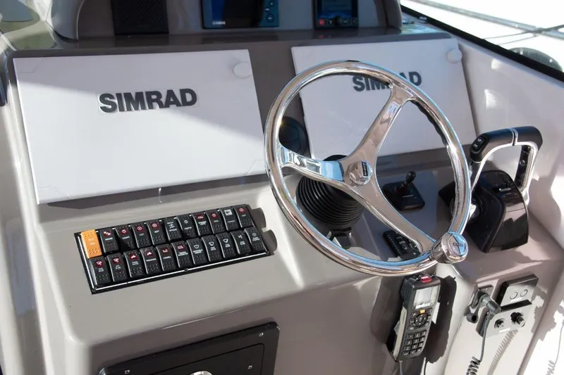  Yacht Photos Pics 2015 Pursuit OS 345 Offshore boat dashboard with Simrad electronics and steering wheel.