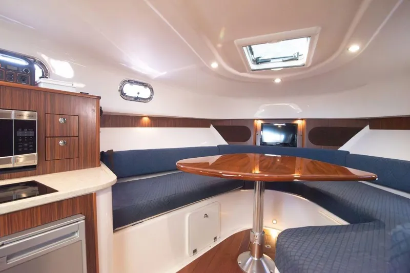  Yacht Photos Pics Luxurious interior of 2015 Pursuit OS 345 Offshore boat with wood accents and seating area.