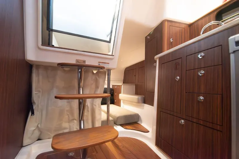  Yacht Photos Pics 2015 Pursuit OS 345 Offshore cabin interior with wooden cabinetry and steps.