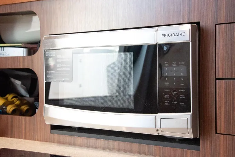  Yacht Photos Pics Frigidaire microwave in 2015 Pursuit OS 345 Offshore boat kitchen, wood paneling.