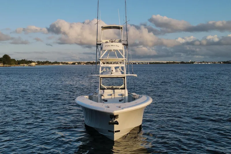 T/t One More Day Yacht Photos Pics 2019 Yellowfin 42 Offshore boat on calm water under a cloudy sky.