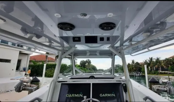 One More Day Yacht Photos Pics 2019 Yellowfin Center Console boat interior with Garmin navigation system, docked by waterfront homes.
