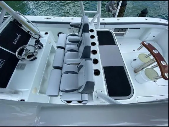 One More Day Yacht Photos Pics 2019 Yellowfin Center Console boat interior with seating and steering wheel, docked by the water.