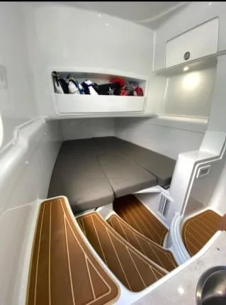 One More Day Yacht Photos Pics 2019 Yellowfin Center Console cabin interior with cushioned bed and wooden steps.