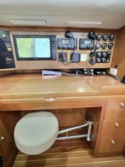 Celebrate Yacht Photos Pics Navigation station in 2003 Taswell 58 yacht with electronic equipment and wooden cabinetry.