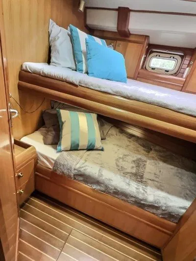Celebrate Yacht Photos Pics Cozy cabin interior of 2003 Taswell 58 yacht with bunk beds and wooden finish.