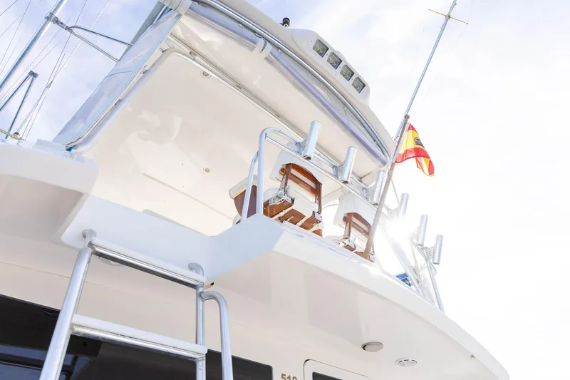 Pecado Yacht Photos Pics 2006 Bertram 510 Convertible yacht with Spanish flag, viewed from below.
