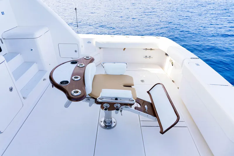 Pecado Yacht Photos Pics Fishing chair on 2006 Bertram 510 Convertible yacht deck, overlooking blue ocean waters.