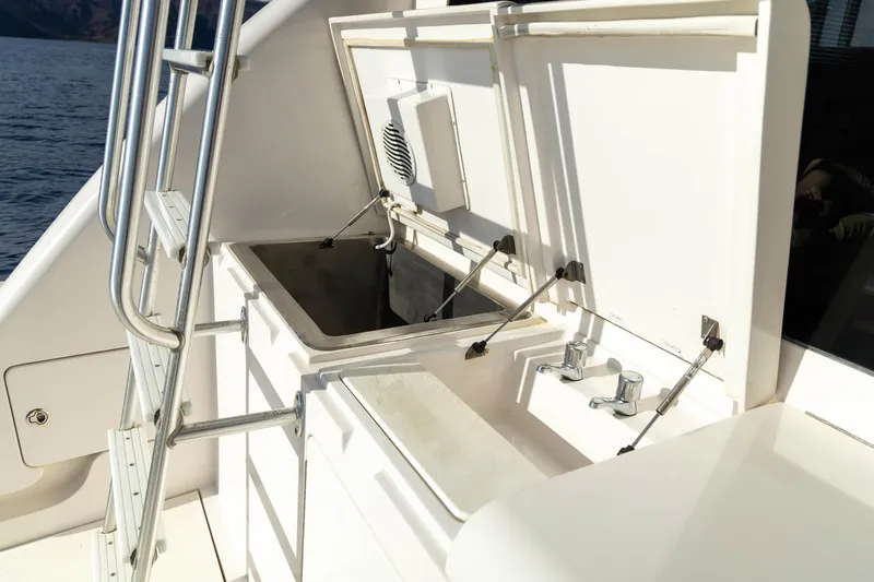 Pecado Yacht Photos Pics 2006 Bertram 510 Convertible yacht deck with open storage compartments and railing.