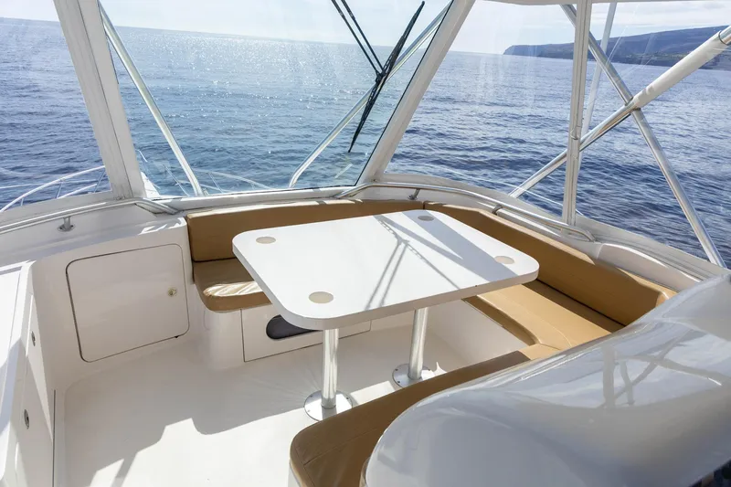 Pecado Yacht Photos Pics 2006 Bertram 510 Convertible yacht interior with table and seating, overlooking the ocean.