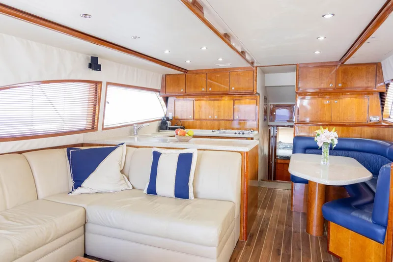 Pecado Yacht Photos Pics Luxurious interior of 2006 Bertram 510 Convertible yacht with leather seating and wooden cabinetry.