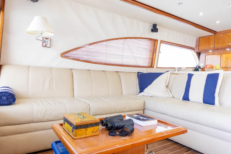 Pecado Yacht Photos Pics Luxurious interior of 2006 Bertram 510 Convertible yacht with cream sofa and nautical decor.