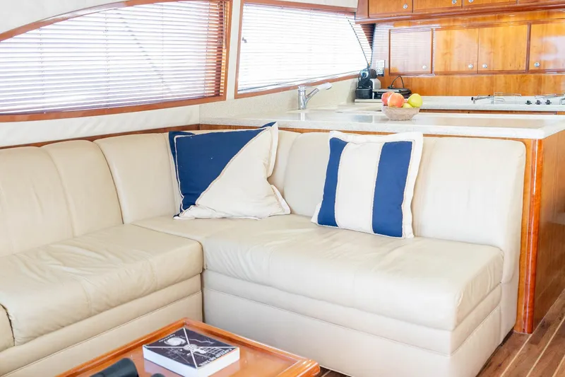 Pecado Yacht Photos Pics Luxurious interior of a 2006 Bertram 510 Convertible yacht with beige seating and nautical decor.