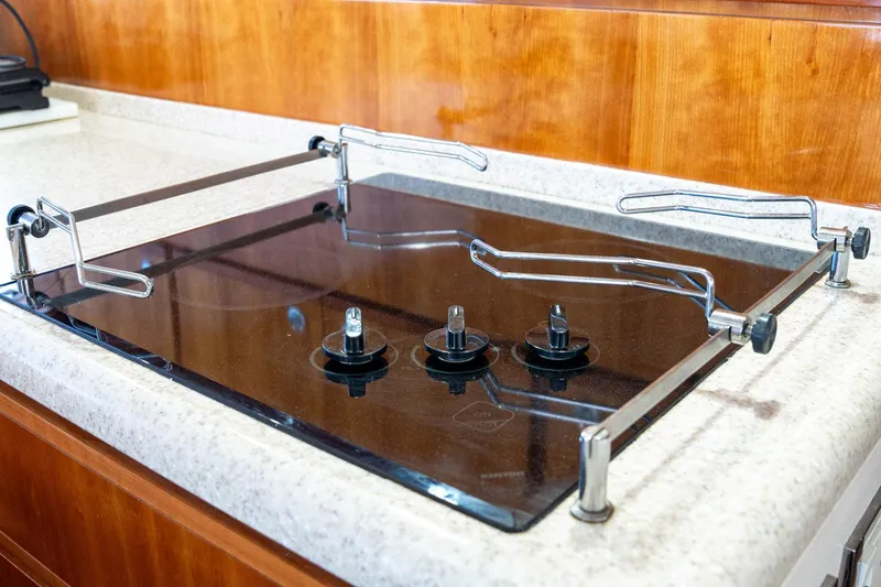 Pecado Yacht Photos Pics Stovetop on 2006 Bertram 510 Convertible yacht, featuring three burners and safety rails.