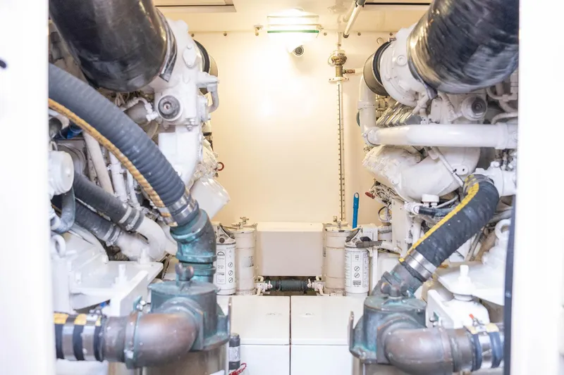 Pecado Yacht Photos Pics Engine room of a 2006 Bertram 510 Convertible yacht, showcasing dual engines and mechanical components.