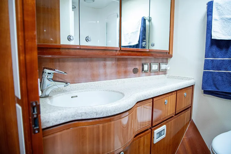 Pecado Yacht Photos Pics Luxurious bathroom in 2006 Bertram 510 Convertible yacht with wooden cabinetry and modern fixtures.