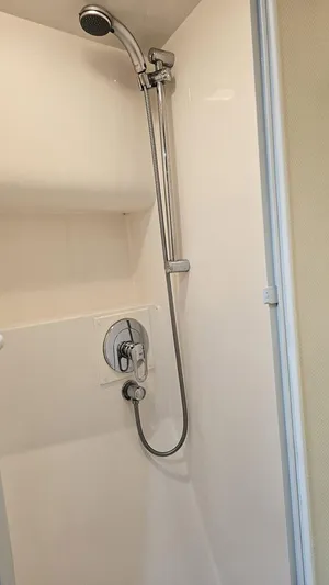 Pecado Yacht Photos Pics Shower area in a 2006 Bertram 510 Convertible yacht, featuring a sleek chrome showerhead.