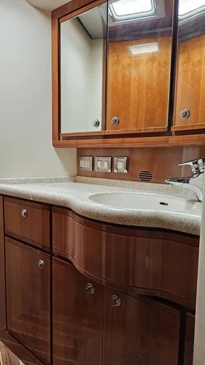 Pecado Yacht Photos Pics Luxurious bathroom interior of 2006 Bertram 510 Convertible yacht with wooden cabinetry.