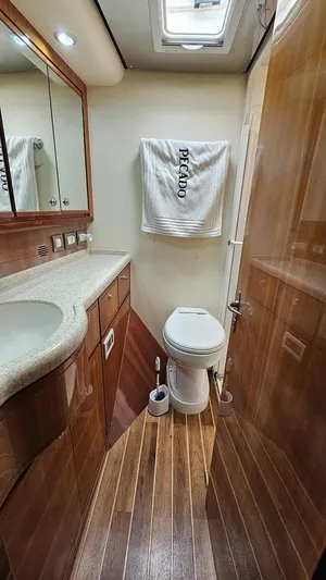 Pecado Yacht Photos Pics Luxurious bathroom in 2006 Bertram 510 Convertible yacht with wood flooring and modern fixtures.