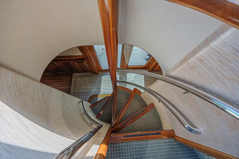 Cerca Trova Yacht Photos Pics Elegant spiral staircase on 2011 Westport 112 yacht, featuring wood and metal accents.