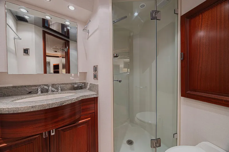Cerca Trova Yacht Photos Pics Luxurious bathroom in 2011 Westport 112 yacht with glass shower and elegant wood cabinetry.