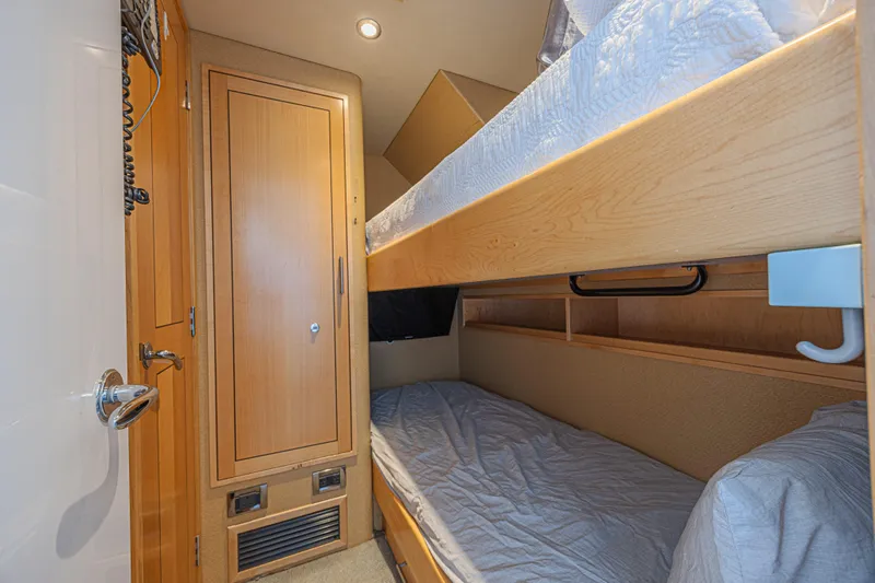 Cerca Trova Yacht Photos Pics Cozy bunk bed cabin in 2011 Westport 112 yacht, featuring wooden cabinetry and soft lighting.