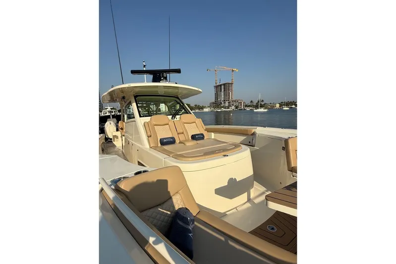 Scout 400lxf Yacht Photos Pics 2024 Scout 400 LXF luxury boat with tan seating, docked by waterfront buildings.
