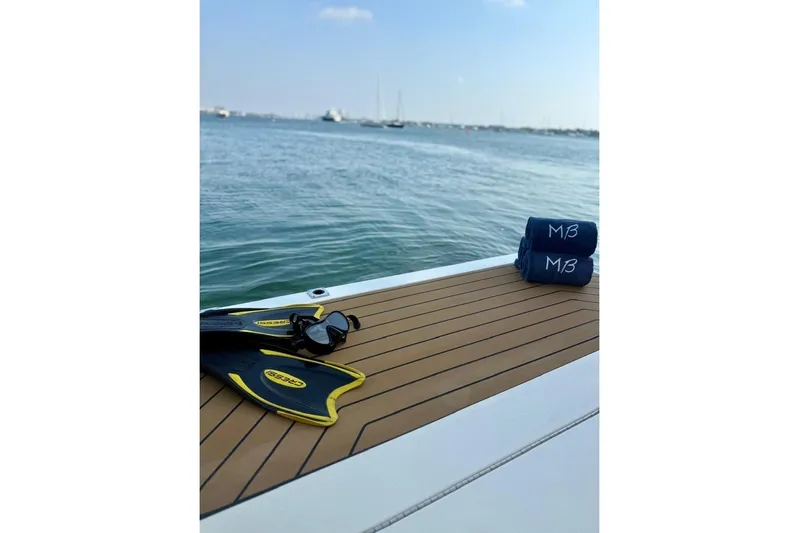 Scout 400lxf Yacht Photos Pics 2024 Scout 400 LXF deck with fins, sunglasses, and towels by the water.