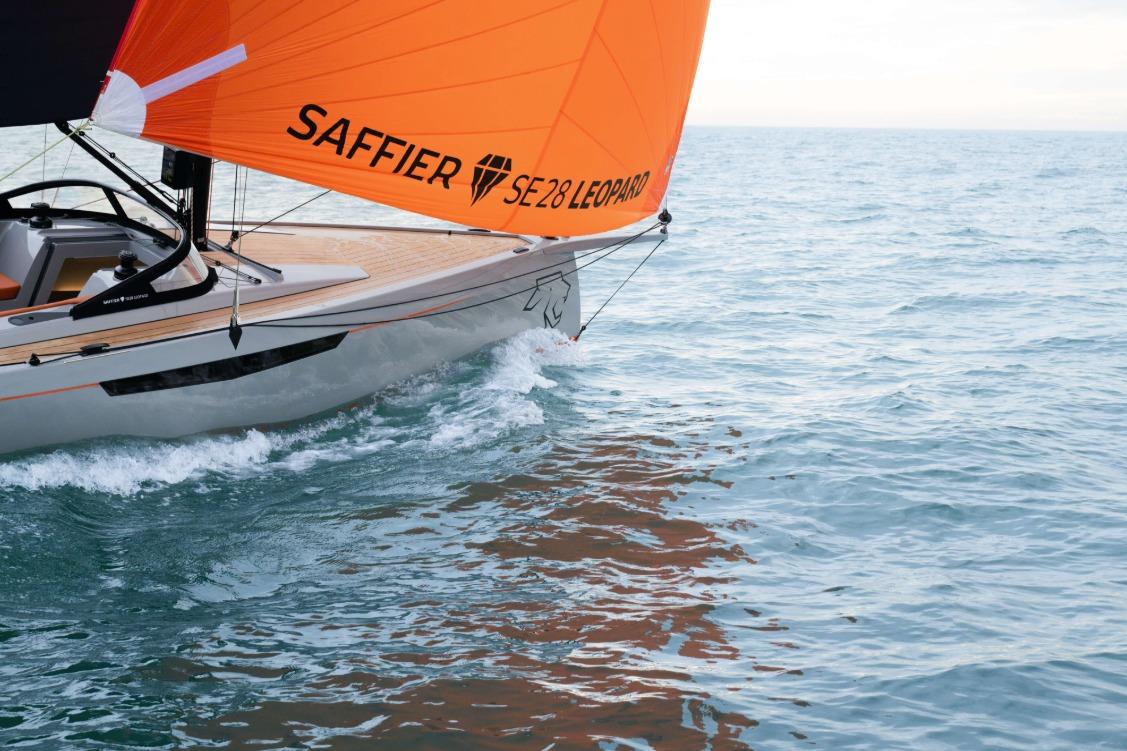 2026 Saffier SE 28 Leopard sailboat with orange sail on open water.