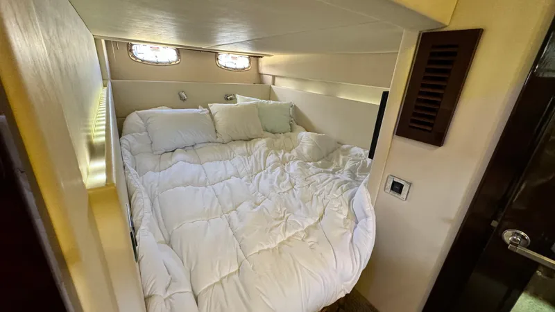  Yacht Photos Pics Cozy bedroom in 2009 Sea Ray 43 Sundancer yacht with white bedding and porthole windows.