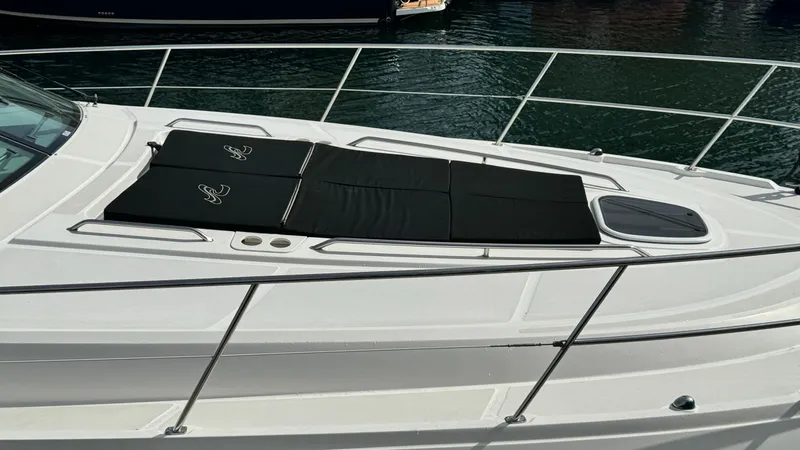  Yacht Photos Pics 2009 Sea Ray 43 Sundancer yacht with sun pads on deck, docked on calm water.