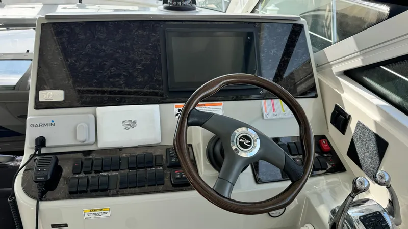  Yacht Photos Pics Control panel of a 2009 Sea Ray 43 Sundancer boat with steering wheel and navigation equipment.