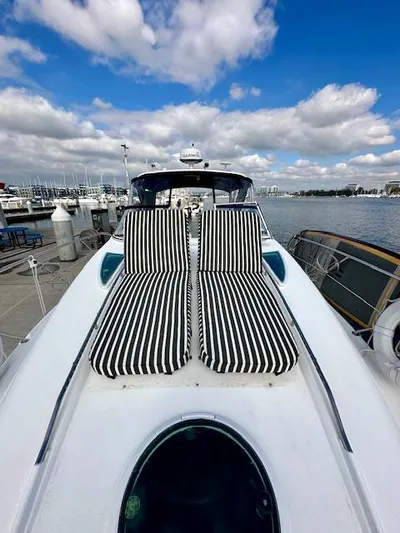 Visionary 21 Yacht Photos Pics 2006 Doral Elegante yacht with striped sun loungers, docked at marina under blue sky.