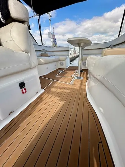 Visionary 21 Yacht Photos Pics 2006 Doral Elegante boat interior with wooden deck and white seating under blue sky.