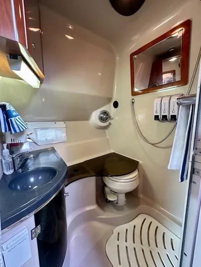 Visionary 21 Yacht Photos Pics 2006 Doral Elegante boat bathroom with sink, toilet, mirror, and shower amenities.