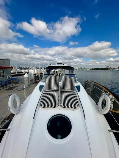 Visionary 21 Yacht Photos Pics 2006 Doral Elegante yacht with striped sun loungers, docked under a blue sky.